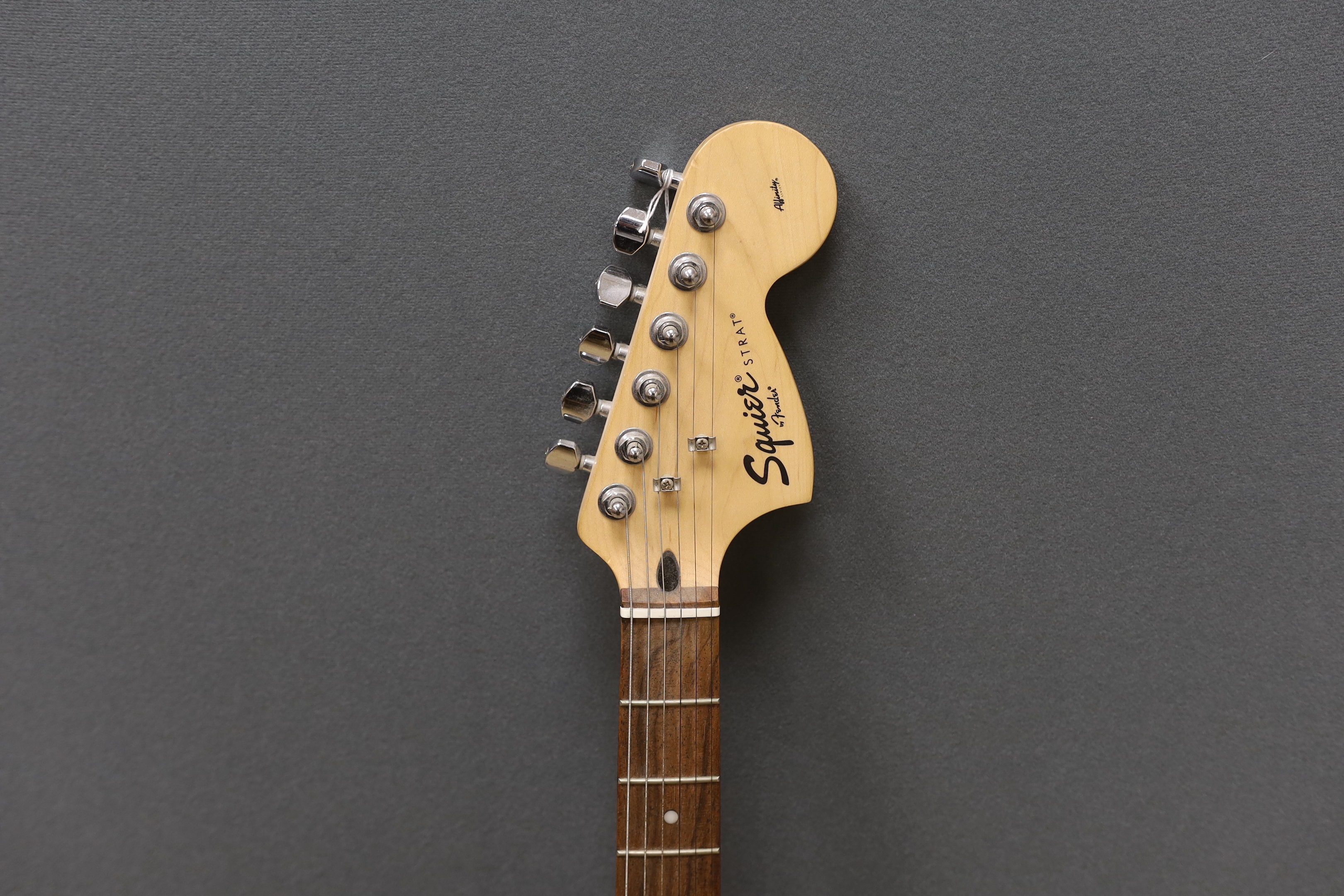A Fender Squier Strat electric guitar with a soft case